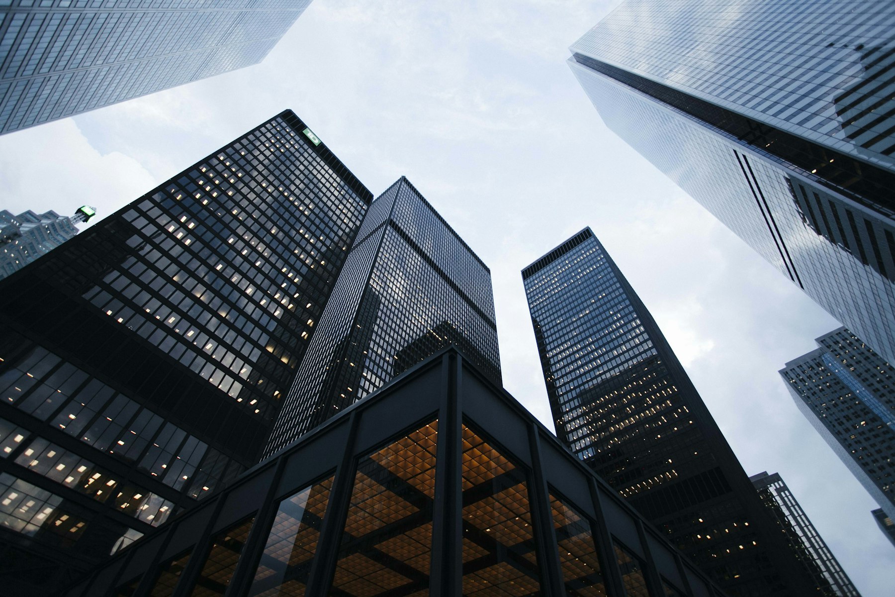 Glass towers seen from below, converging upward