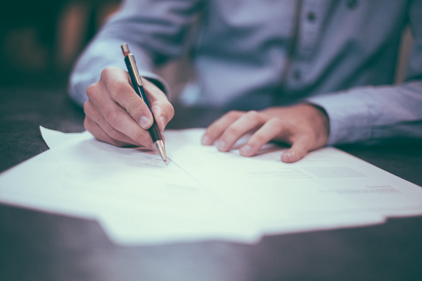 Hands marking up a printed document at a desk